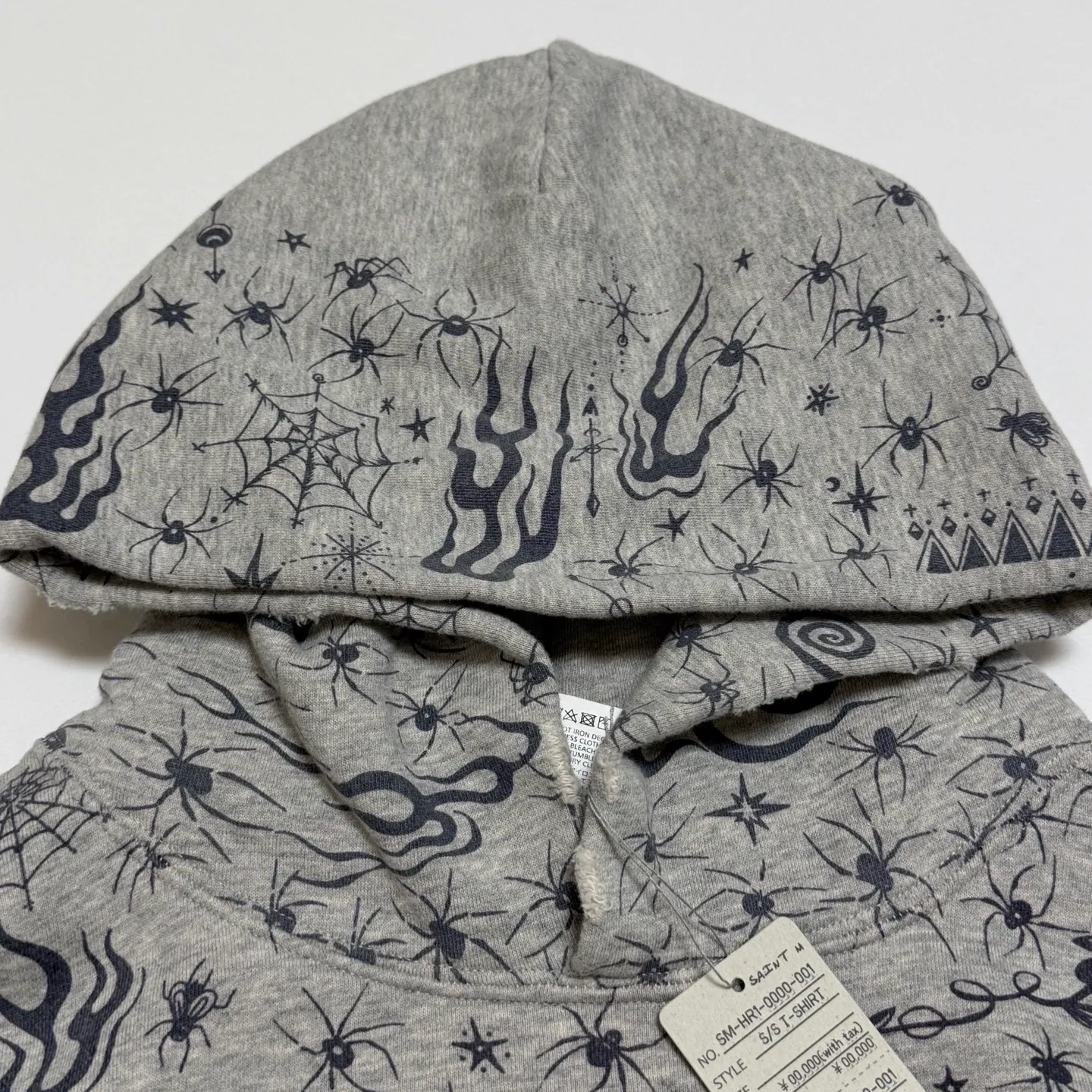 SAINT Mxxxxxx x DR. WOO HOODIE ' Dr.Woo ' /GRY Flame Swirl Spider Web Hoodie Distressed Gray S-XL Custom-woven and dyed nostalgic gray fabric. After printing, the garment is sprayed with potion to cause the fabric to oxidize and fade. A large number of artificial fabric destruction processes are added to make the whole piece of clothing look aged and unique like a work of art. This hoodie is co-branded with a famous tattoo design artist and customized with a full set of Dr.Woo accessories. Bringing you authentic items!